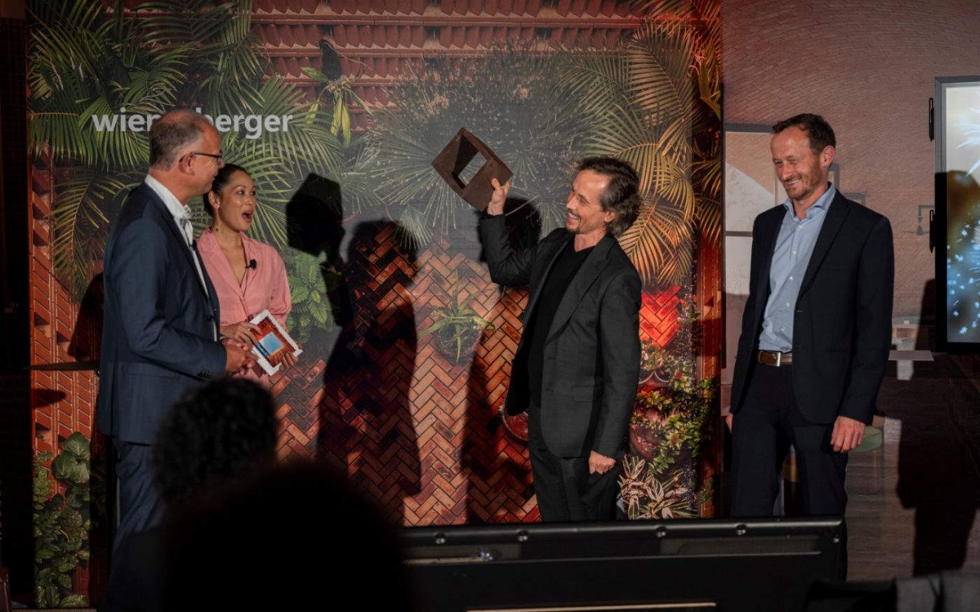 The Grand Prize winners handing over a brick of the winning project to Heimo Scheuch