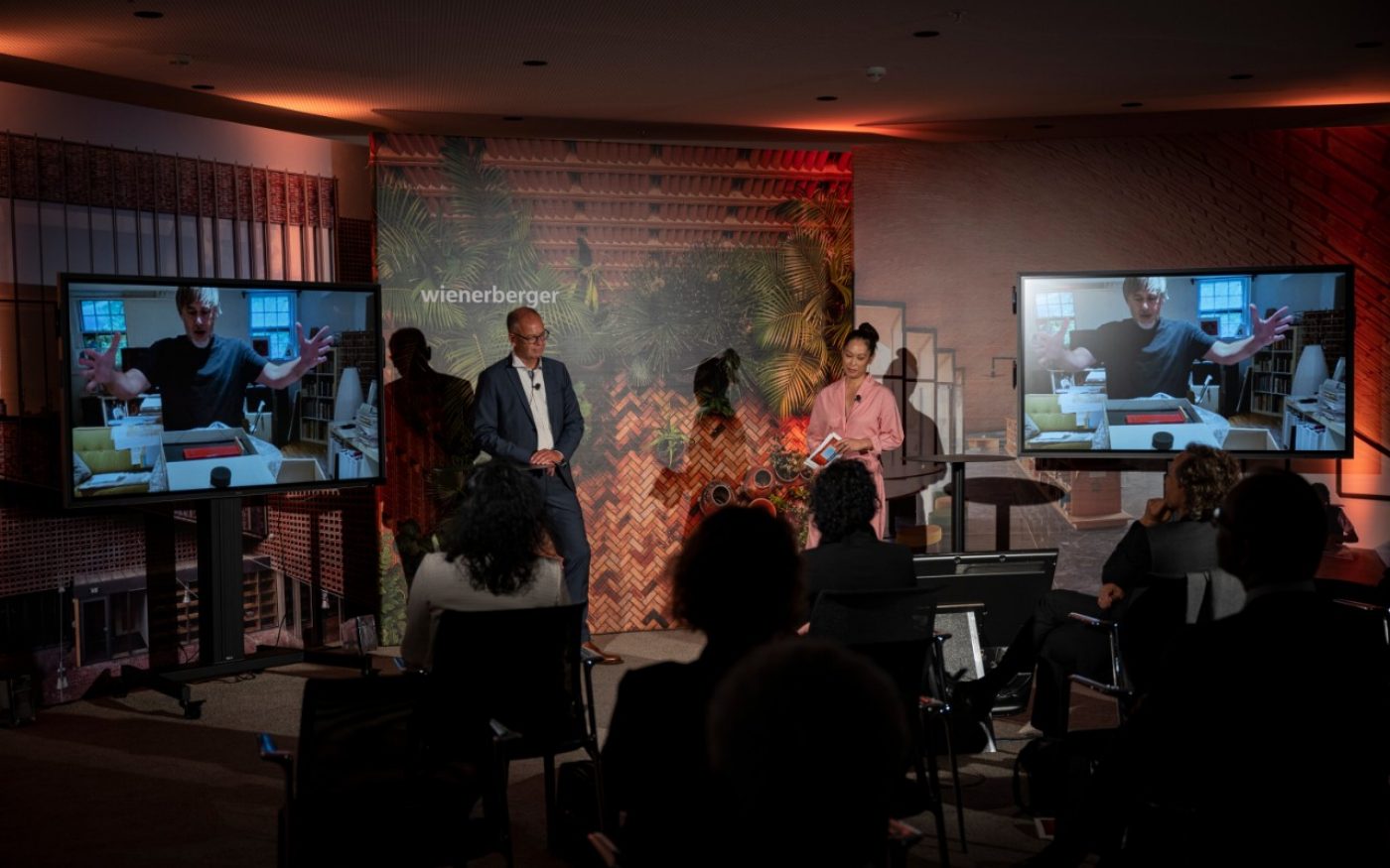 Heimo Scheuch and Miriam Hie on stage; Rafi Segal with his trophy on screen